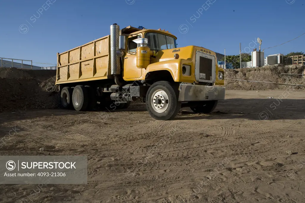 Big yellow Mack dump truck construction earth mover on location on a contruction site