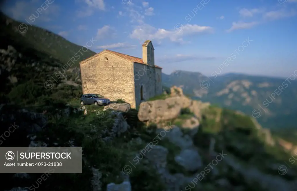 hatchback car parked old building church cliff ledge valley rocks beautiful different bellows