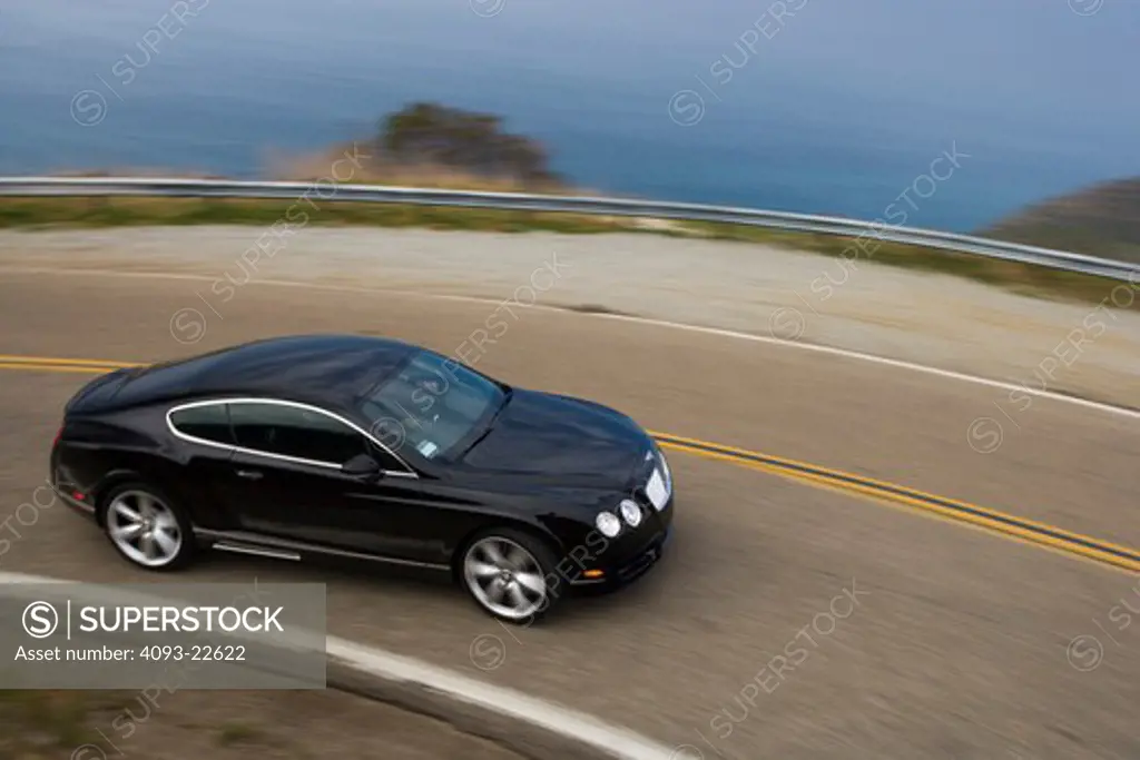2009 Bentley Continental GT. Action view of a Black Bentley Continental GT on a rural mountain road.