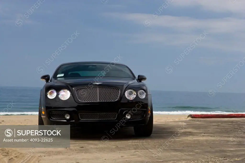 Straight on nose view of a 2009 Bentley Continental GT at the beach - shoreline.