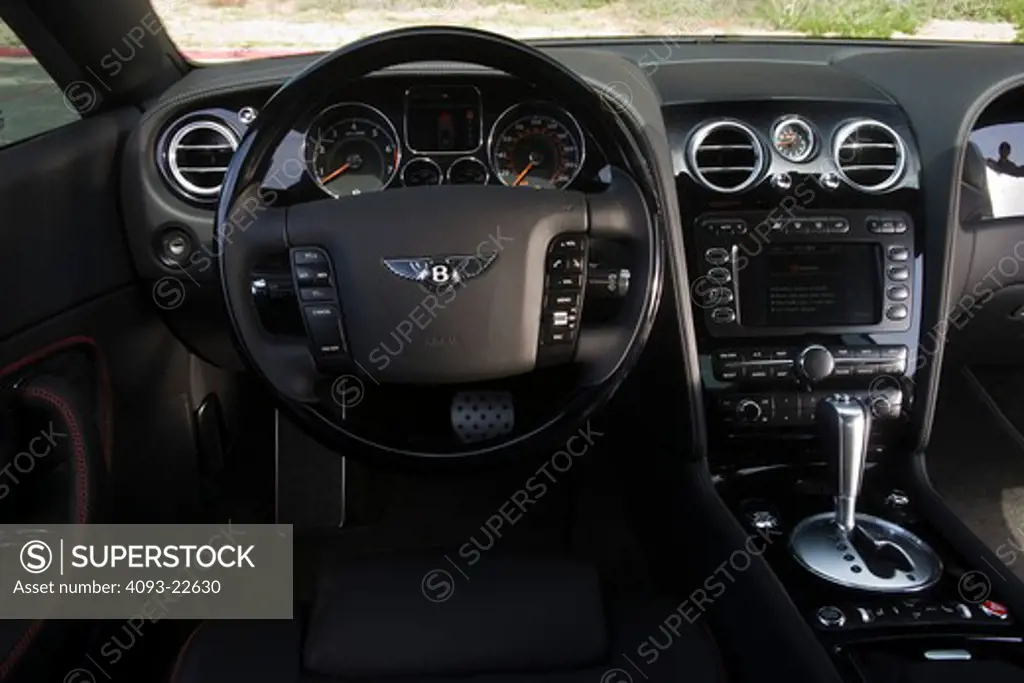Interior view of a 2009 Bentley Continental GT showing the front instrument panel, dash, dashboard, steering wheel, shifter, radio and GPS navigation system.
