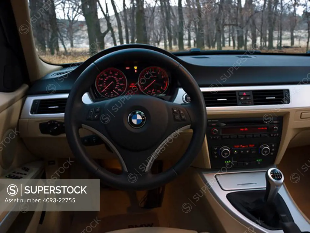Interior view of a 2009 BMW 330i showing steering wheel, instrument panel ( IP ), shifter, ventilation system.