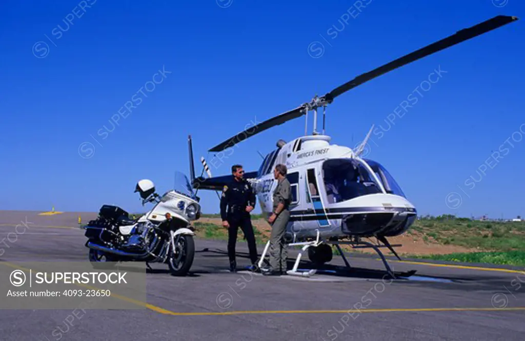 poiliceman officer Heli talking landing pad 1000 cc pilot Bell Jet Ranger helicopter