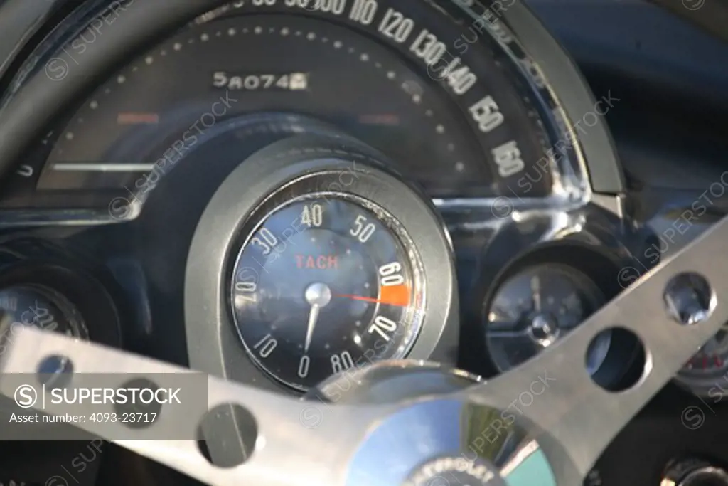 Speedometer and tachometer detail view of a 1958 Chevrolet Corvette. Taking its name from the corvette, a small, maneuverable fighting frigate, the first Corvettes were virtually handbuilt. The outer body was made out of a revolutionary (at the time) new composite material called fiberglass. Underneath that radical new body were standard Chevrolet components, including the Blue Flame inline six-cylinder engine, two-speed Powerglide automatic transmission, and drum brakes from Chevrolet's regular