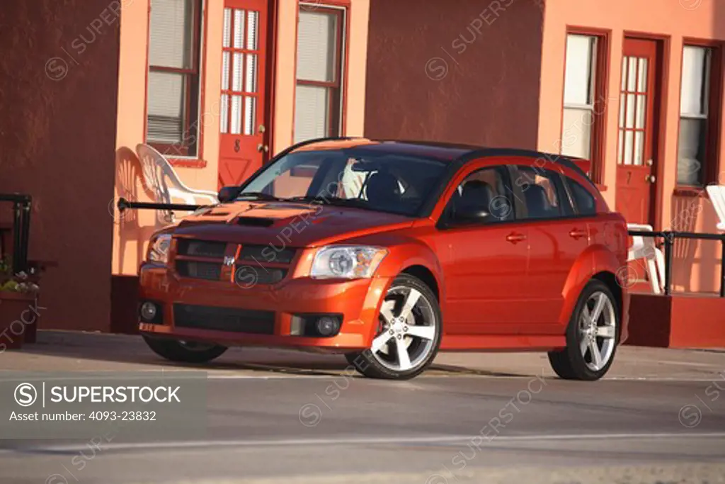 2008 Dodge Caliber SRT4 parked in front of a row of houses on an empty road.