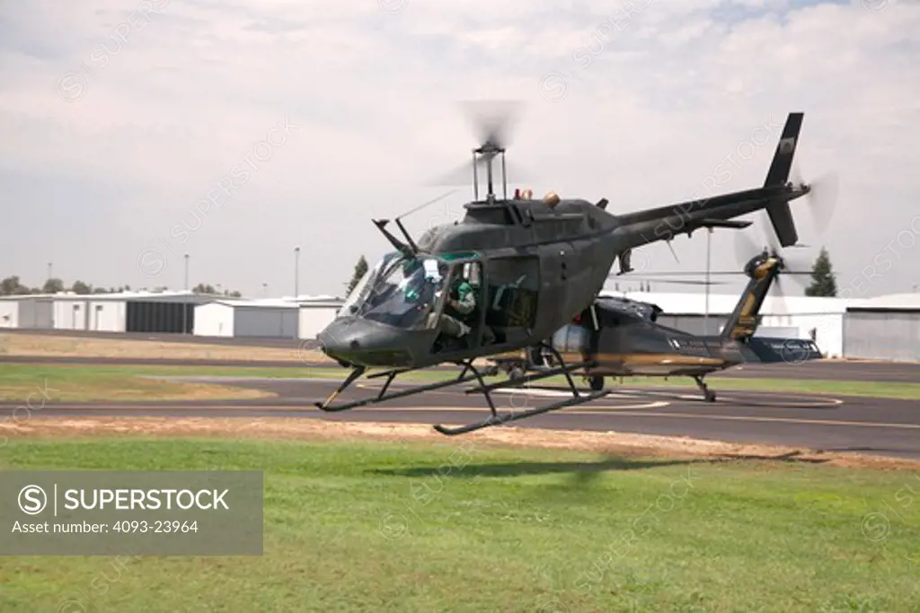 Bell OH-58 Kiowa hovering, taking off from an airport in Porterville, California. The OH-58 is based on the Bell 206 Jet Ranger civilian helicopter.