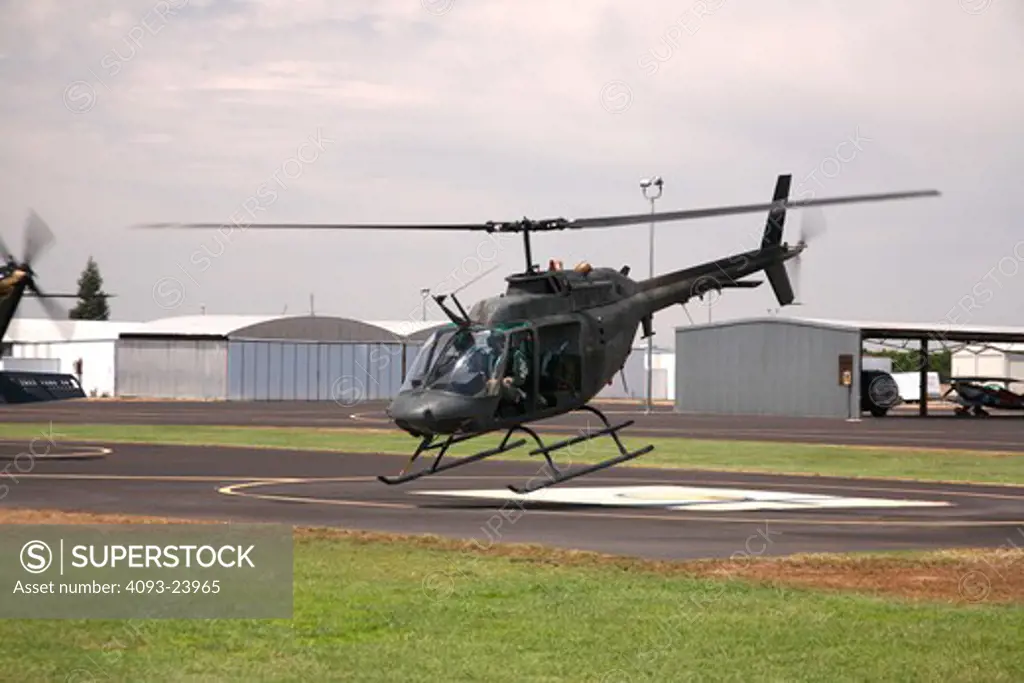 Bell OH-58 Kiowa hovering, taking off from an airport in Porterville, California. The OH-58 is based on the Bell 206 Jet Ranger civilian helicopter.
