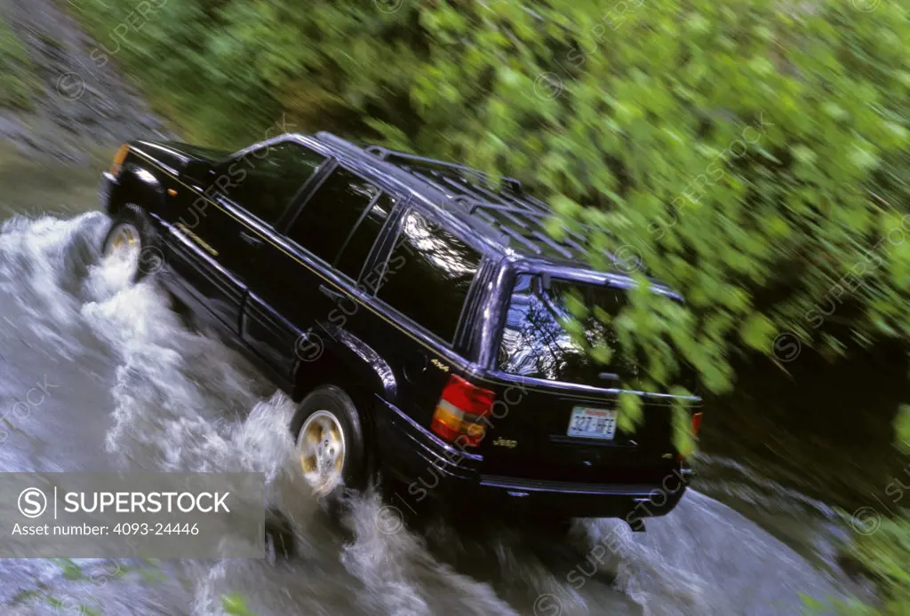 high angle Jeep Grand Cherokee 1998 1990s black water splash leaves foliage
