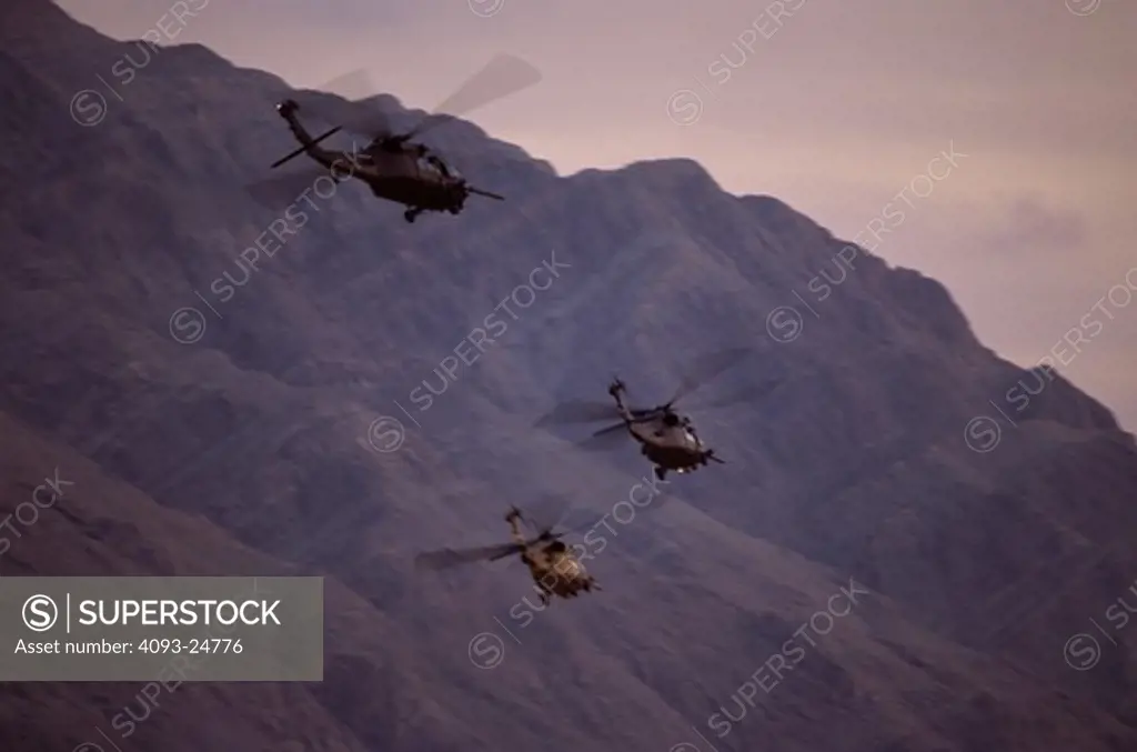 Three USAF Sikorsky MH-60 Blackhawk combat search and rescue/special operations helicopters flying at Nellis AFB, NV. Sunrise Mountain in the background.