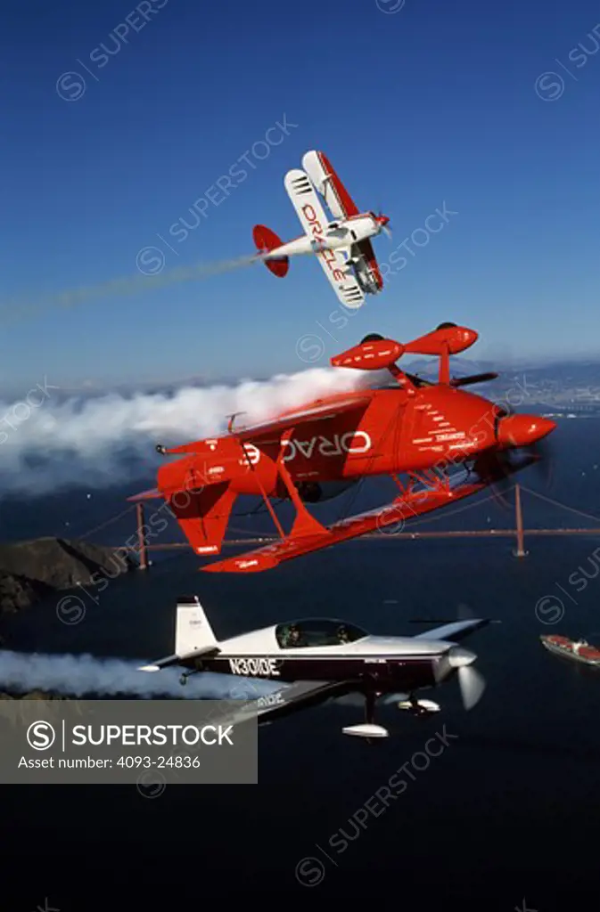 Sean Tucker in Oracle Challenger, Extra 300 and Pitts S2 with the Golden Gate Bridge in the background