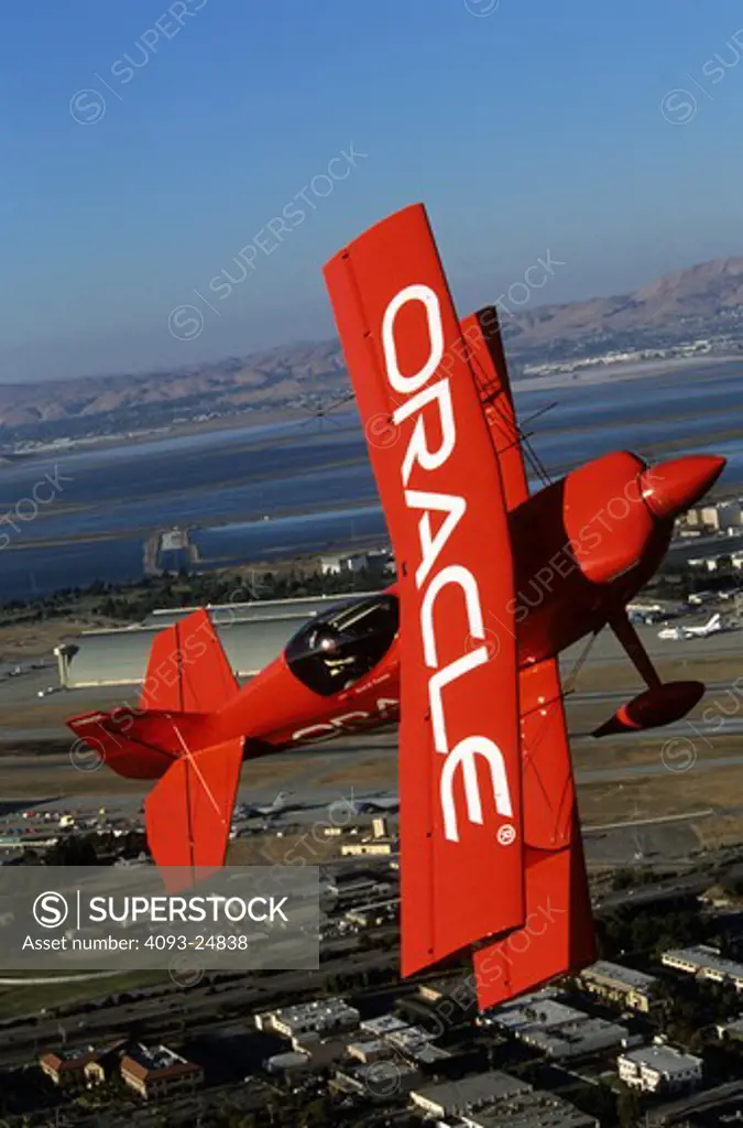 Sean Tucker in Oracle Challenger with Moffett Federal Air Field (formerly Moffett Naval Air Station) with the blimp hangers visible.