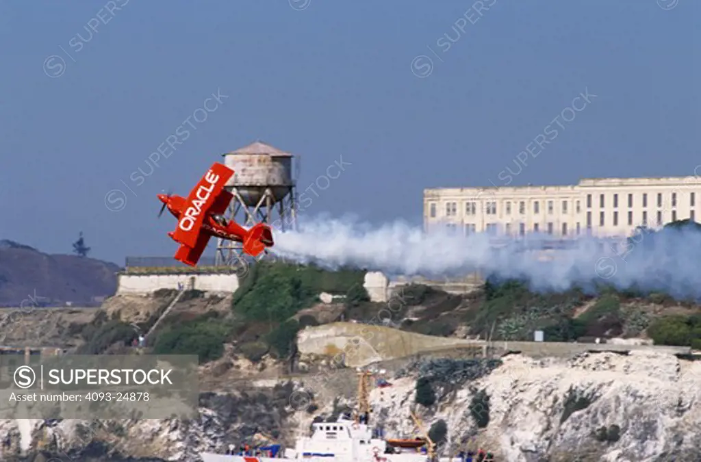 Air show performer Sean Tucker in the Oracle Challenger trails smoke as he flies in front of Alcatraz Island during San Francisco's Fleetweek air show.