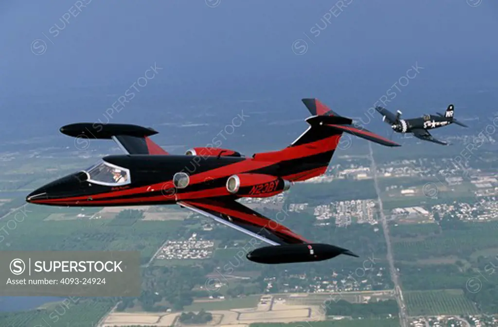 Learjet and Vought F4U Corsair formation modern private jet and WWII fighter.