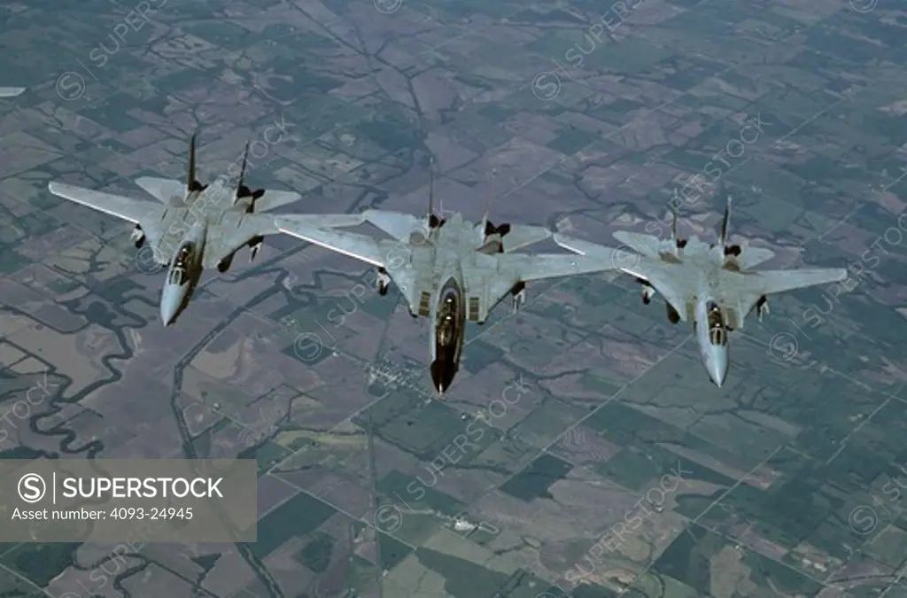 Three US Navy Grumman F-14D Tomcats of VF-31 Tomcat aka Felix in tight formation photographed from a tanker over land.