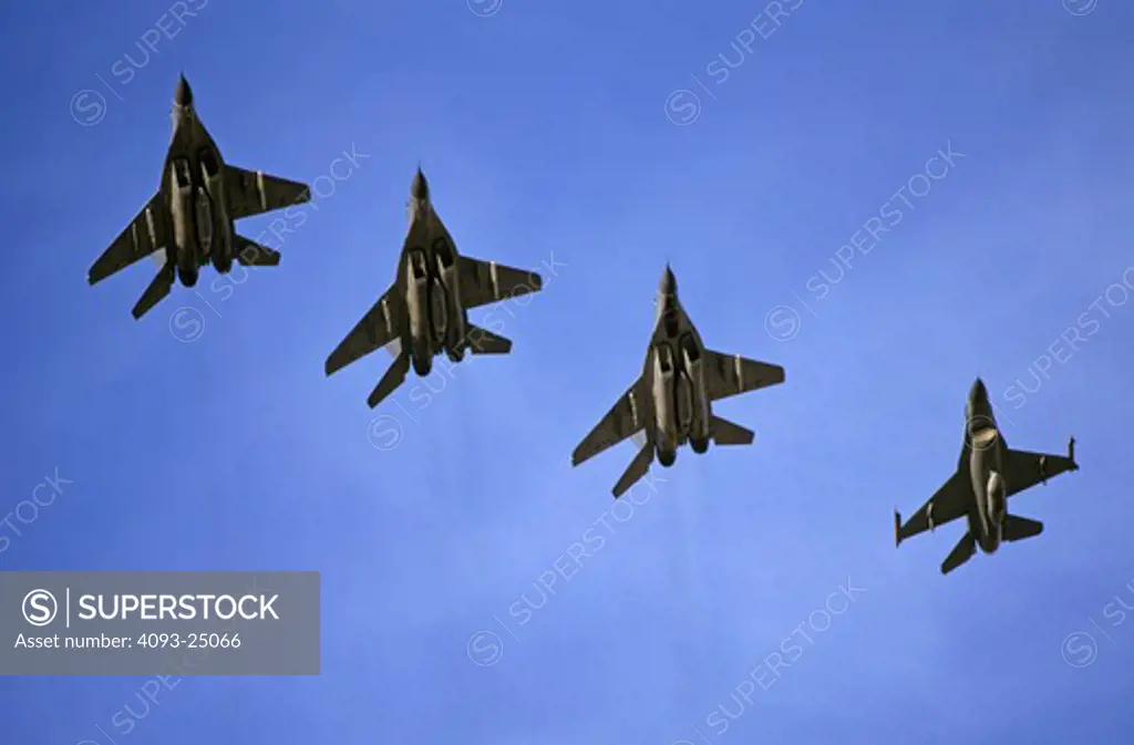 A three ship formation of German Air Force (Luftwaffe) Mig-29 Fulcrums with a USAF F-16 Fighting Falcon Aggressor of the 64th Aggressor Squadron escort  returns from Red Flag exercise mission with ordnance  Nellis AFB  NV.
