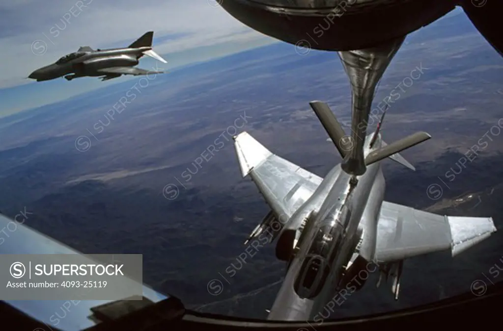 a pair two-ship formation of German Air Force (Luftwaffe) McDonnell F-4 Phantom II as seen from a KC-135 Stratotanker tanker boomer position. One F-4 is attached to the refueling boom and the other waits in the quick-refueling position