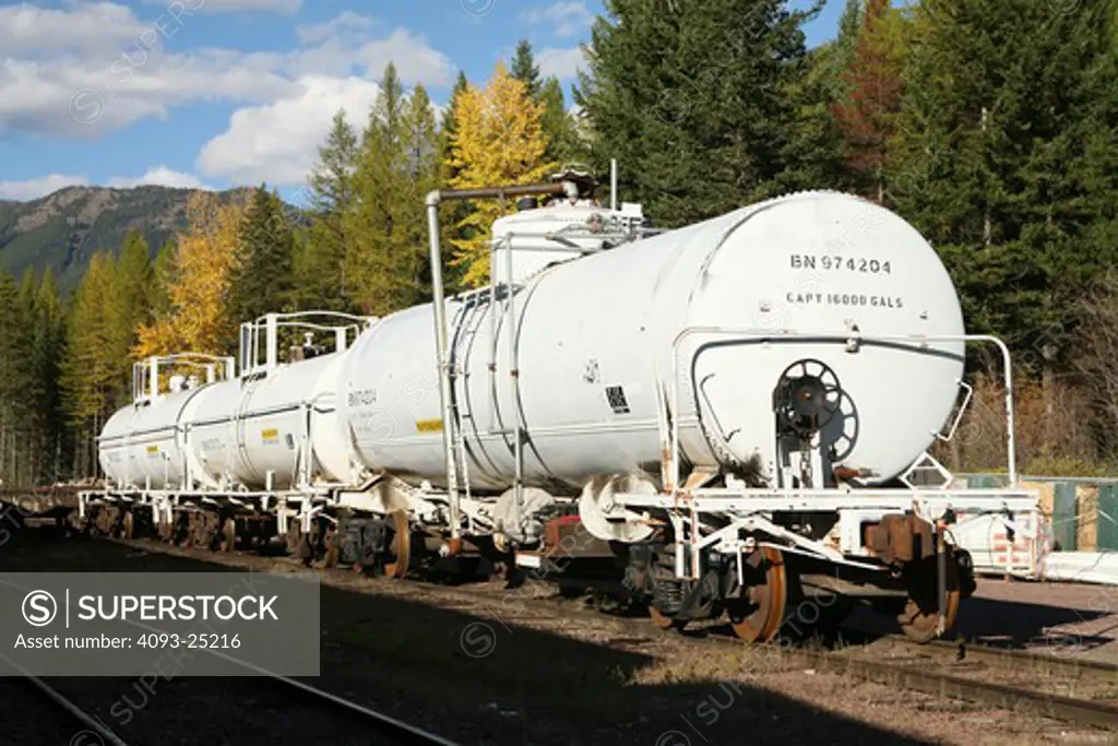 White freightcar mountains trees tanker