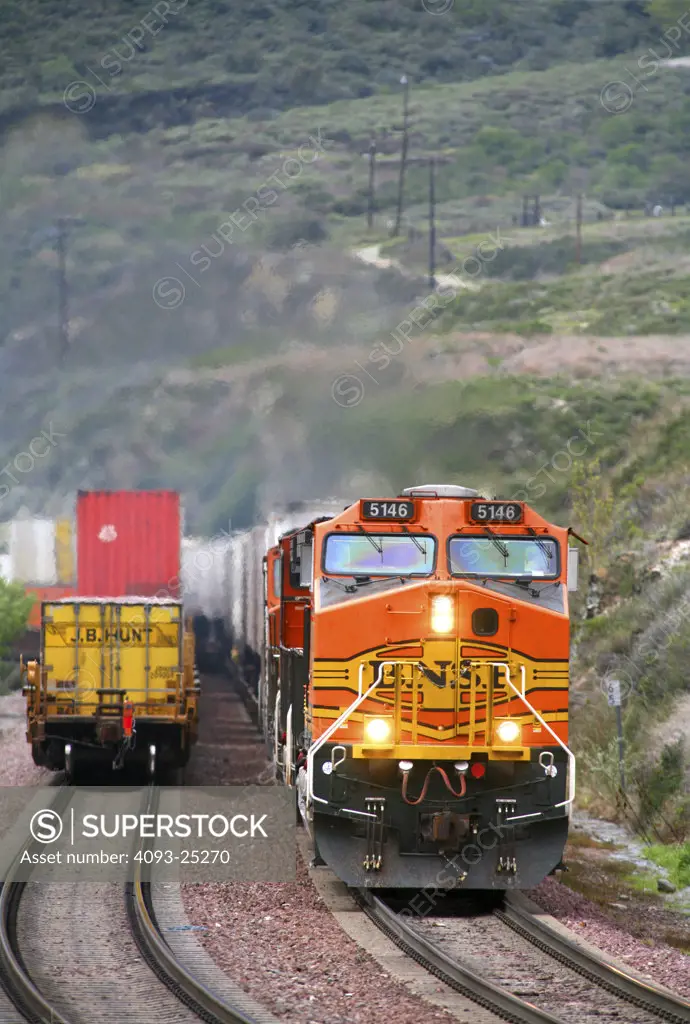 Two BNSF intermodal freight trains pass on another in the Blue Cut area of the Cajon Pass near San Bernardino California.