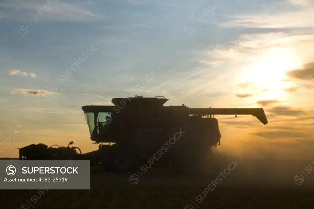 Case IH AFX8010 Axial-FlowCase combine harvester harvesting wheat field at sunset