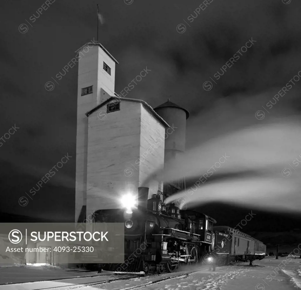 1910 4-6-0 engine Steam locomotive number 40 in front of a coaling tower and water tower at night view