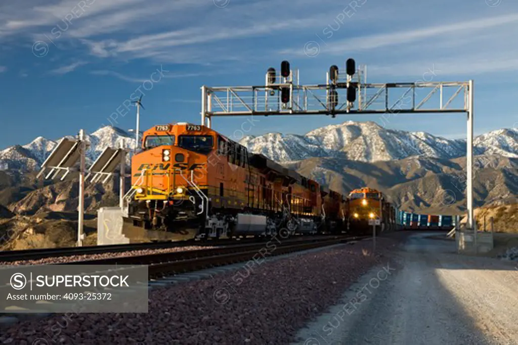 BNSF diesel locomotive pulling an intermodal train  and passing a railroad signal