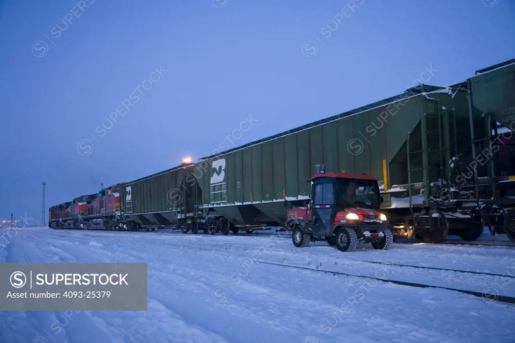 BNSF covered hopper train in the snow at the railroad yard