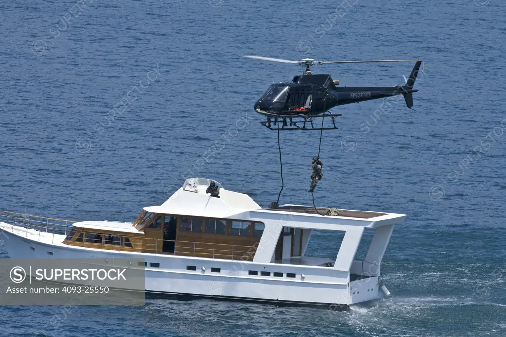 Eurocopter AS350 Ecureuil A-Star Helicopter flying over the Pacific Ocean near Malibu, CA during a Fast Rope type military operation onto a yacht.