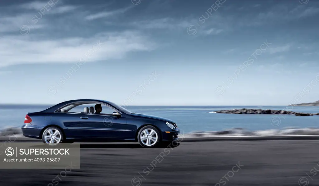 2006 Mercedes Benz CLK 350 driving along road by sea, side view
