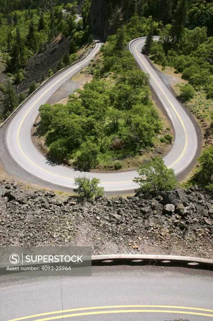 background landscape with a road wrapping around trees.  different perspectives with the guardrail directly below.