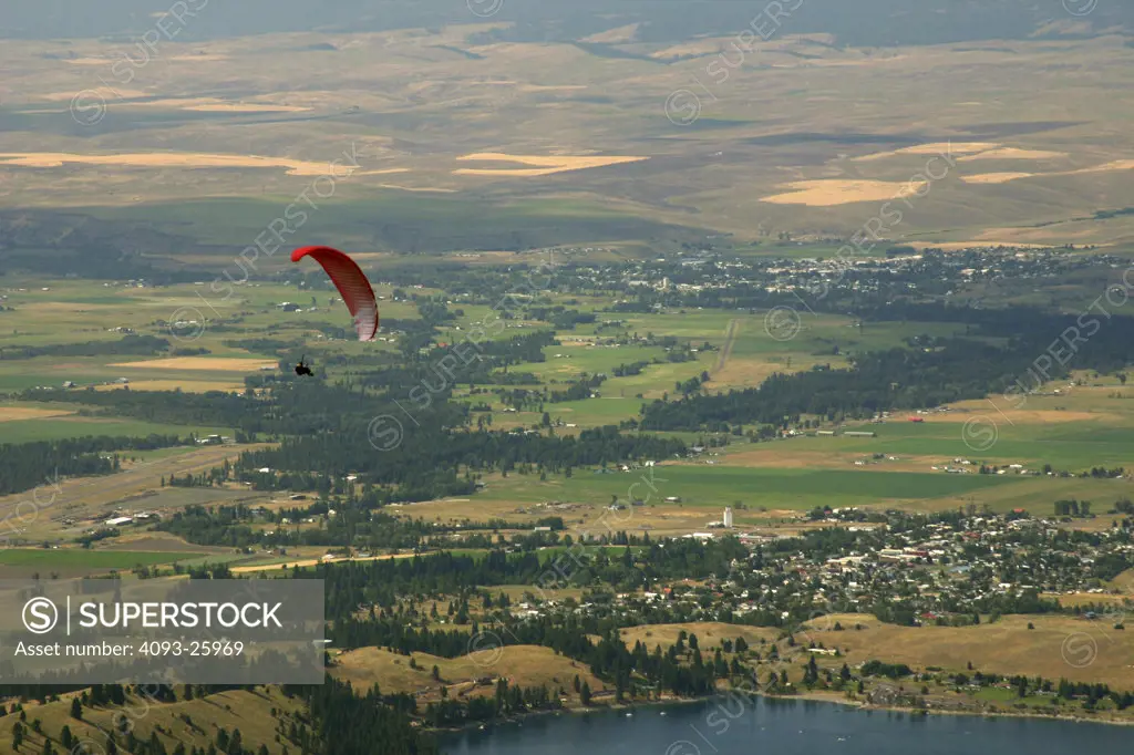 red flying glider overr a full landscape background.