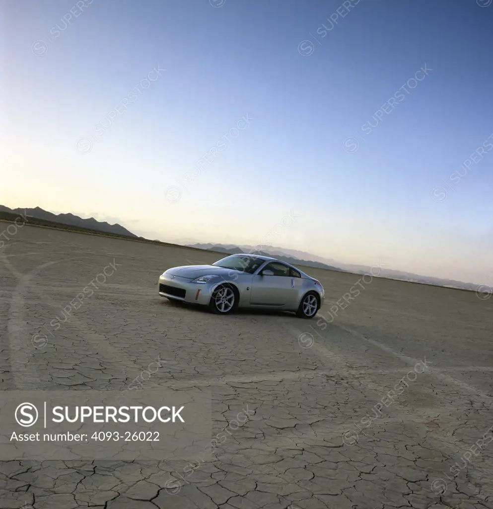 2004 Nissan 350Z in the desert dry lake bed salt flats with dramatic sky and clouds