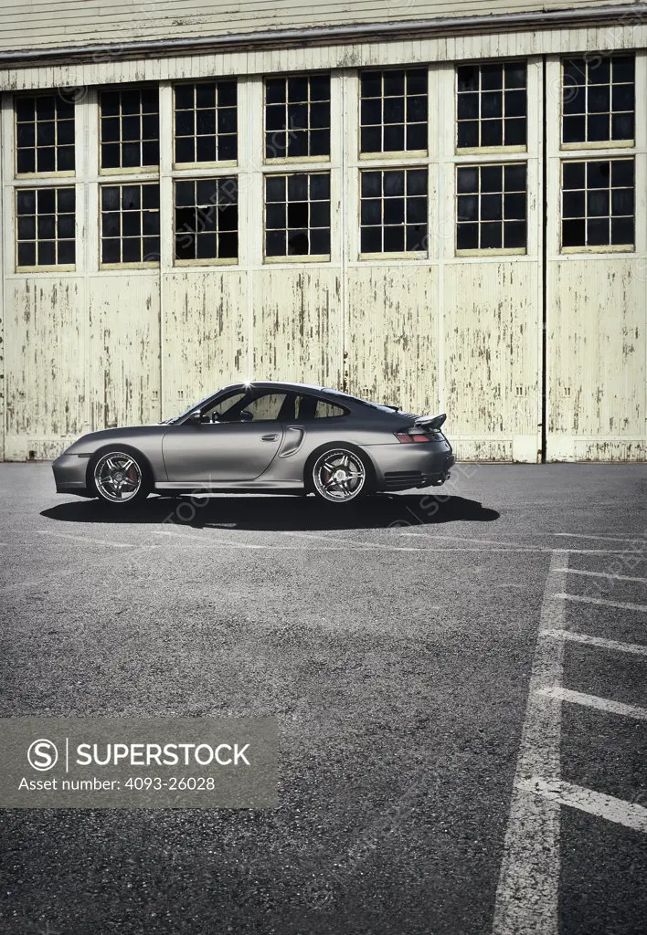 2004 Porsche 996 Turbo parked in an industrial area in front of a weathered building with very high windows worn walls