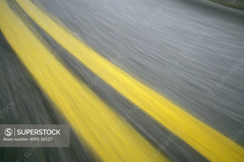 double yellow lines blur asphalt pavement POV street