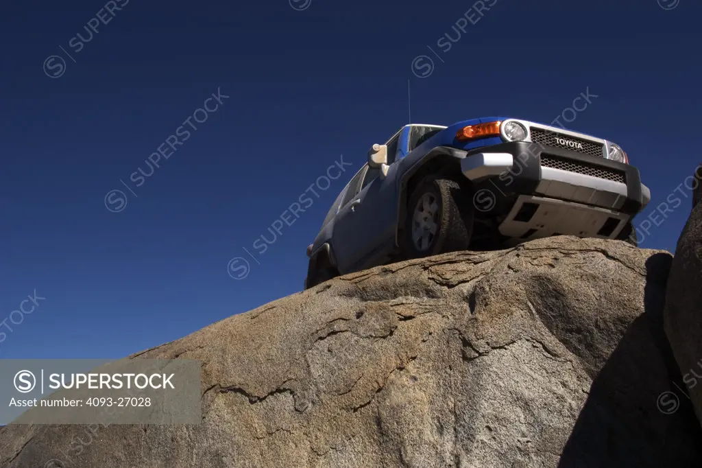 2007 Toyota FJ Cruiser, offrooading in baja california. On top of rocks with blue sky.