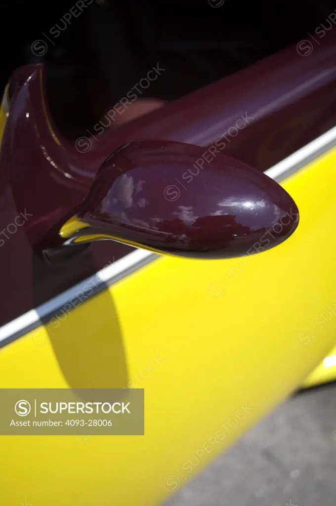 A close up detail shot of an old early 1940's Chevrolet hot rod custom paint job and rearview mirror