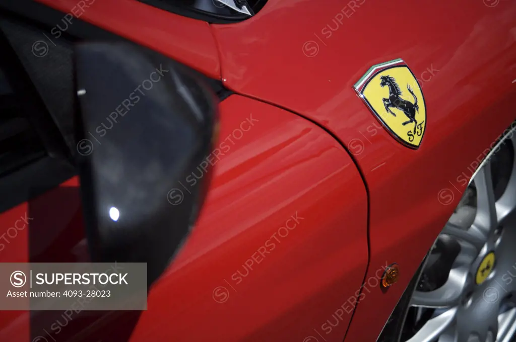 A close up detail shot of a 2006 Ferrari 430 Scuderia rearview mirror and logo