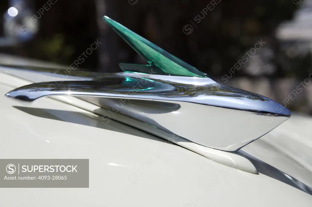 A close up detail shot of an old Cadillac emblem on the top of the hood ornament