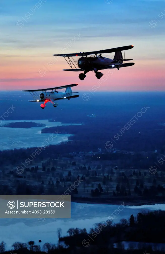 2010 WACO YMF-5D and WACO owned test aircraft flying over countryside at dusk