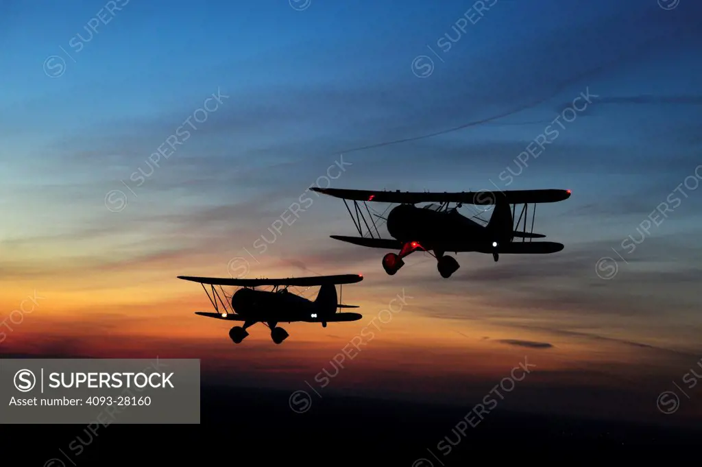 2010 WACO YMF-5D and WACO owned test aircraft flying over countryside at dusk