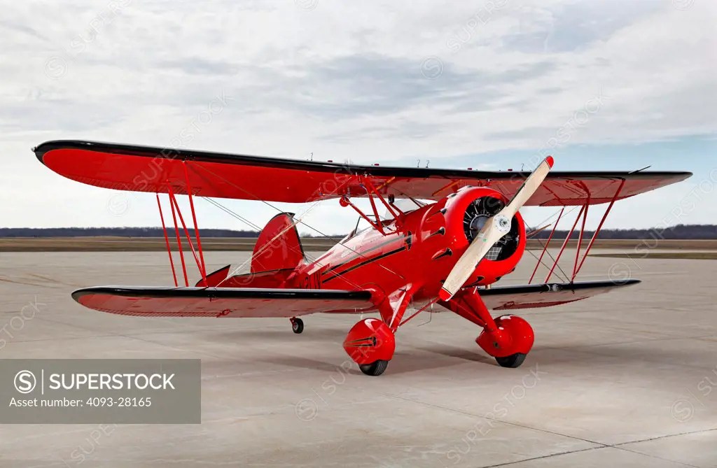 Red 2010 Waco YMF-5D on a rural airport ramp, front 3/4