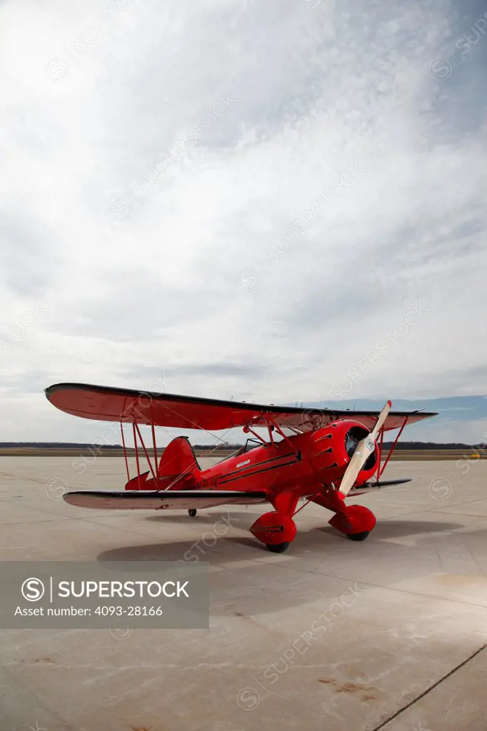 Red 2010 Waco YMF-5D on a rural airport ramp, front 3/4