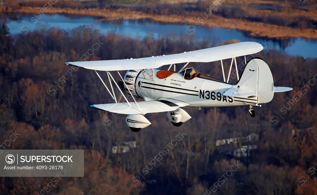 2010 Waco Classic test aircraft in flight over rural countryside, rear 7/8