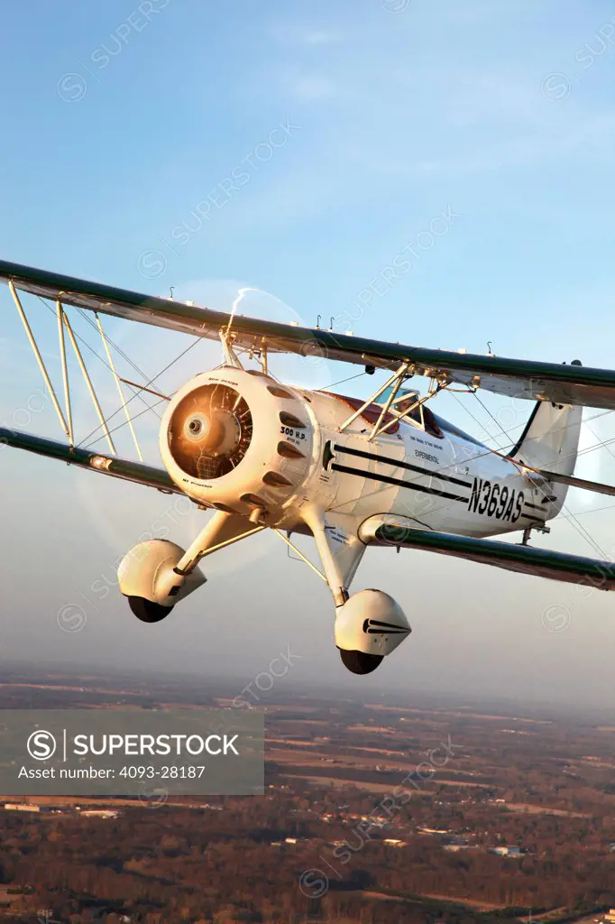 2010 Waco Classic test aircraft in flight over rural countryside, front 3/4