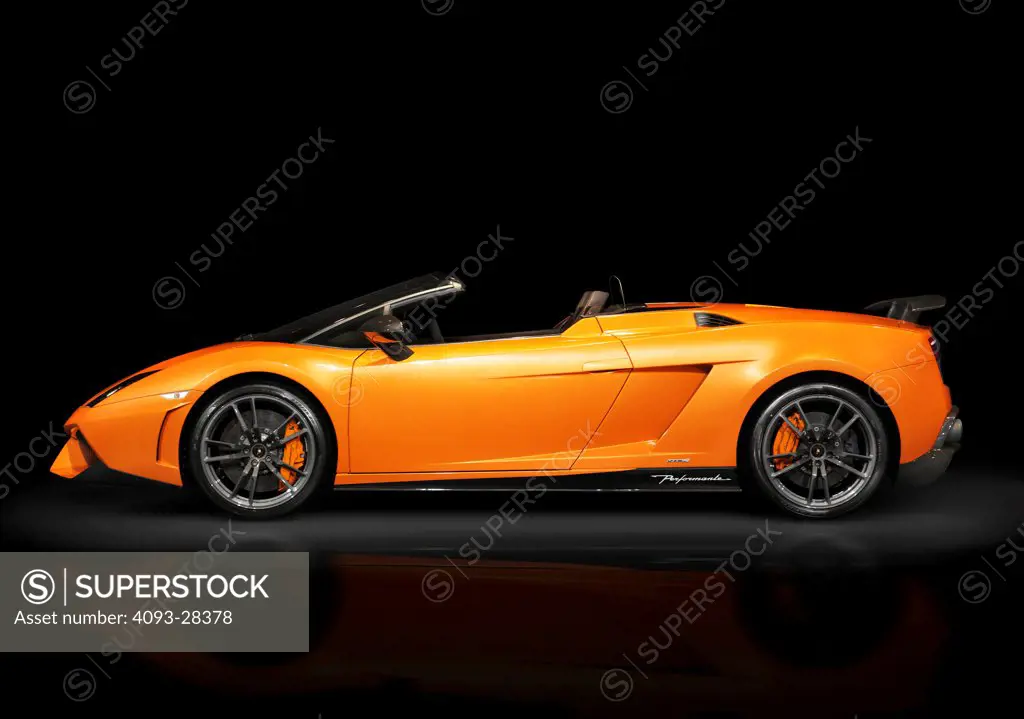 Static profile of an orange 2012 Lamborghini Gallardo LP570-4 Spyder Performante in the studio