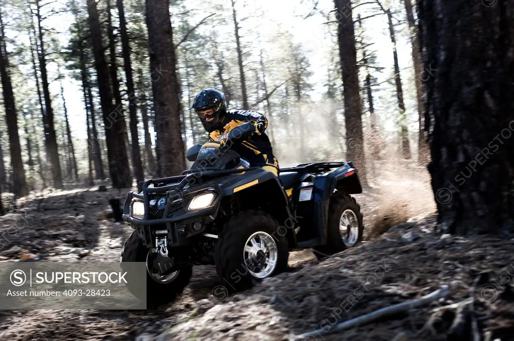 Front 3/4 action of a 2010 Can-Am Quad ATV on a rural, tree lined trail