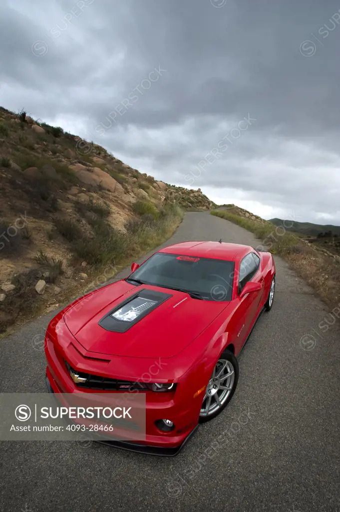 Front 7/8 static view of a red 2011 Callaway Chevrolet Camaro on a narrow, rural road