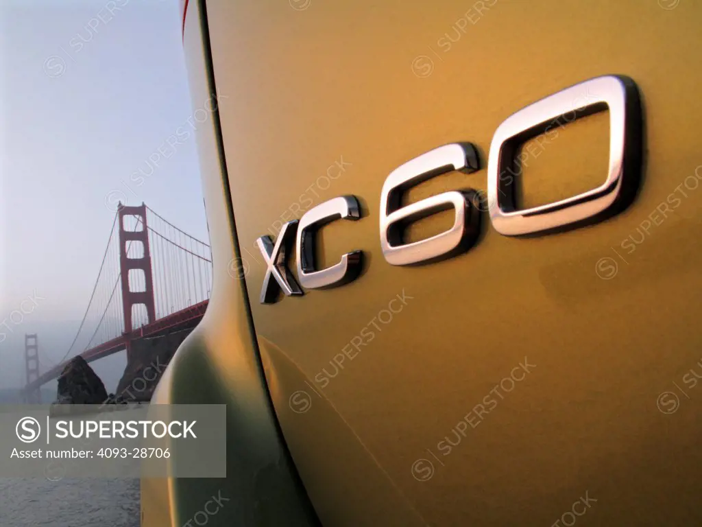 2010 Volvo XC60 close-up on emblem with suspension bridge in background