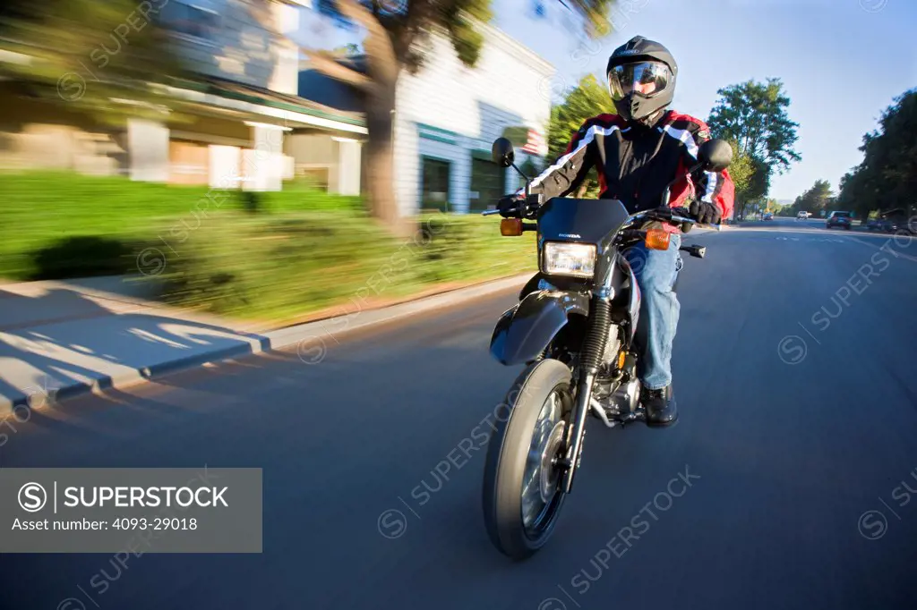 2009 Honda CRF230M in action on suburban road, front 3/4