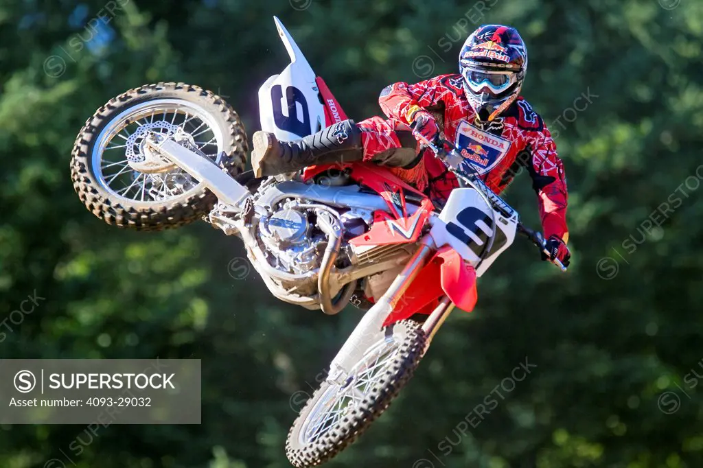 2008 Honda CRF 450R with rider Ivan Tedesco on dirt track course in forest, mid air jump
