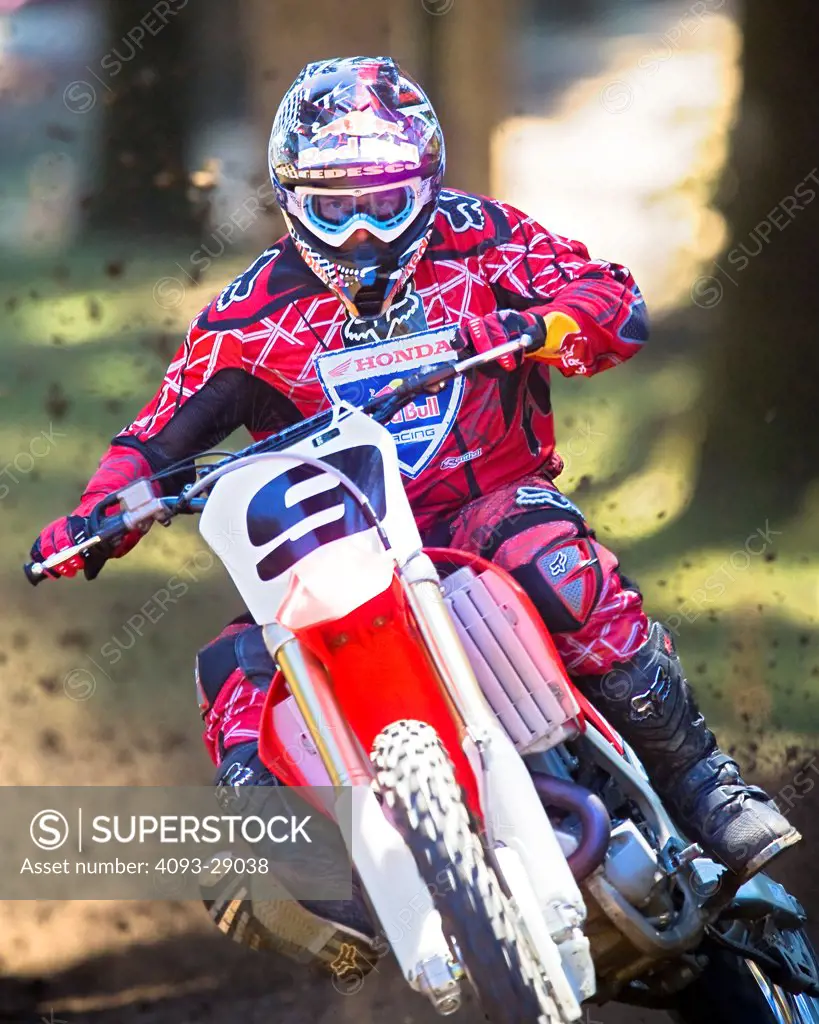2008 Honda CRF 450R with rider Ivan Tedesco on dirt track course in forest, front view